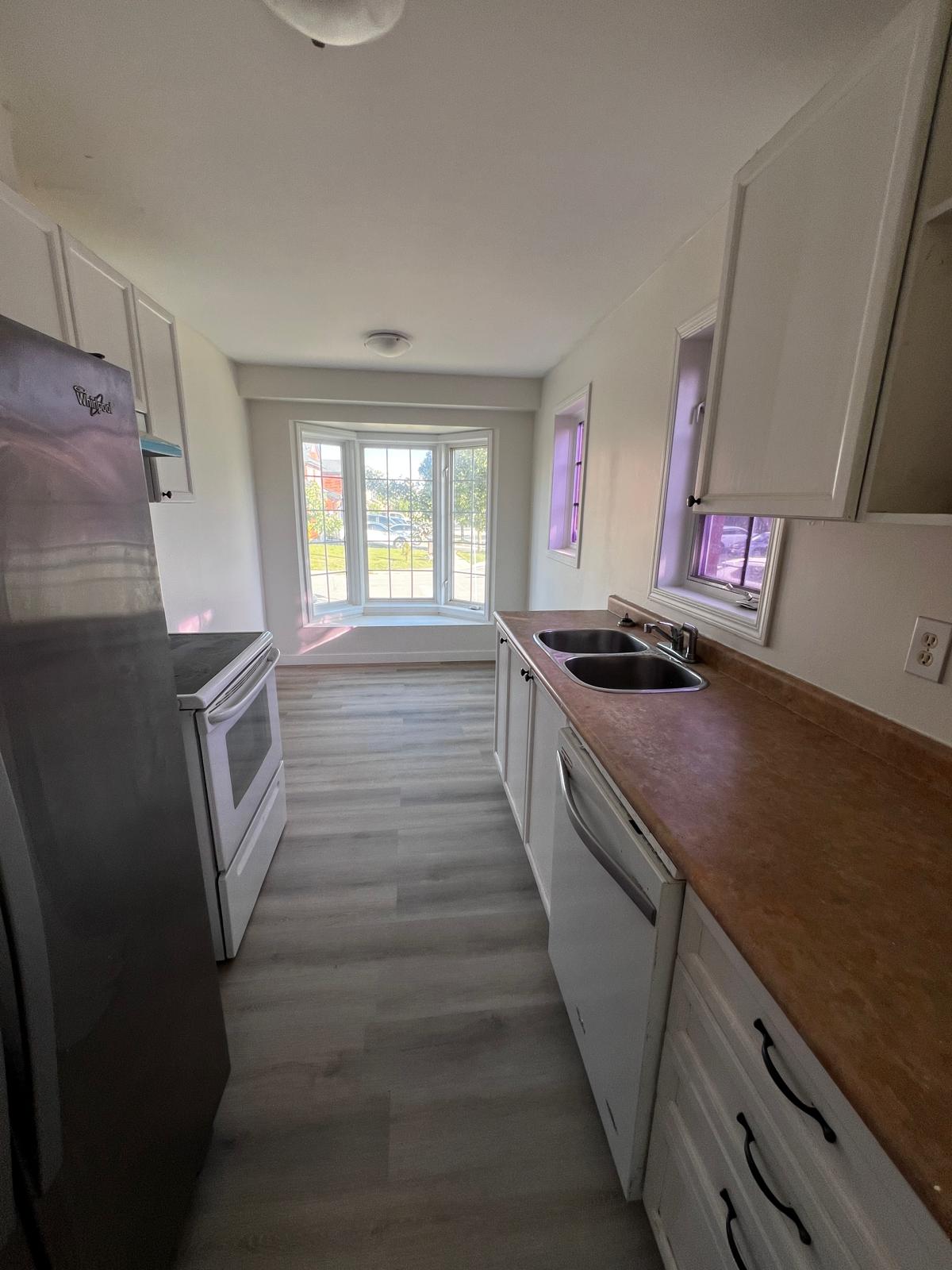 A bright, freshly renovated kitchen with a bay window